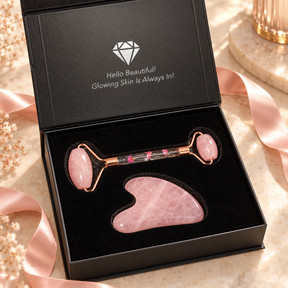 Open black gift box containing a pink face roller and gua sha